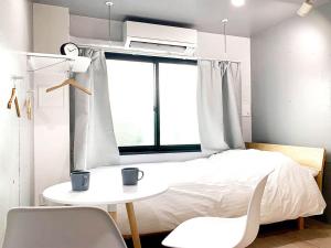 a bedroom with a bed and a table and chairs at Itos Ebisu in Tokyo