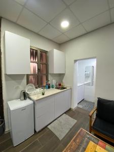 a kitchen with white cabinets and a sink at BenGurion 25 Apartment in Haifa