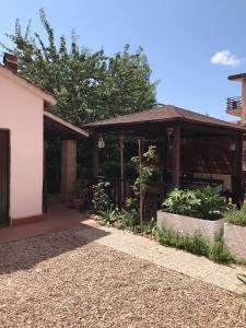 a house with a pavilion next to a building at Holiday rooms with private bathroom in Acilia