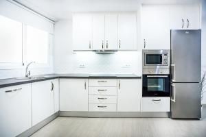 マラガにあるAlonso de Palencia City Center Apartmentのキッチン(白いキャビネット、ステンレス製の冷蔵庫付)