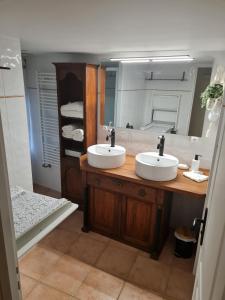 a bathroom with two sinks and a large mirror at Laronde Gites a Baragane in Taillant