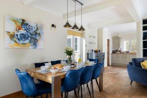 uma sala de jantar com uma mesa e cadeiras azuis em Draycott Farm em Chipping Campden