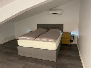 a bed sitting in a room under an attic at Loft- Ferienwohnung perfekt für Fahrradfahrer in Nortrup