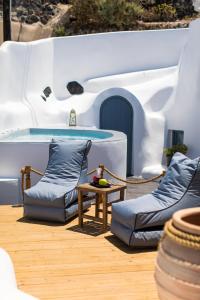 a patio with two couches and a swimming pool at Gemini Cave in Oia