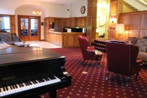 um quarto com um piano e uma sala de estar com cadeiras em Boulder Dam Hotel em Boulder City