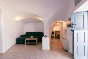 a living room with a green couch and a table at Gemini Cave in Oia +19 photos