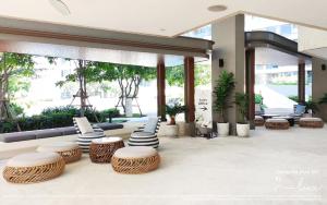 a lobby with wicker chairs and tables in a building at VERANDA HUAHIN BY LUX in Hua Hin