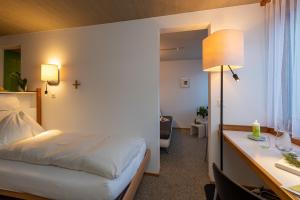 a bedroom with a bed and a desk with a lamp at Kloster Ilanz in Ilanz