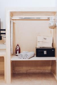 a shelf with a microwave and towels on it at Gemini Cave in Oia