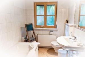 La salle de bains blanche est pourvue d'une baignoire, de toilettes et d'un lavabo. dans l'établissement Ferienwohnung Geigl, à Bad Reichenhall 11 autres photos