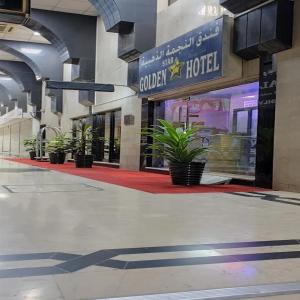 a hotel with potted plants in front of a building at Golden Star Hotel in Dubai