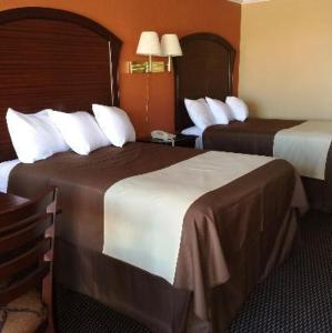 a hotel room with two beds and a table at Americas Best Value Inn Schulenburg in Schulenburg
