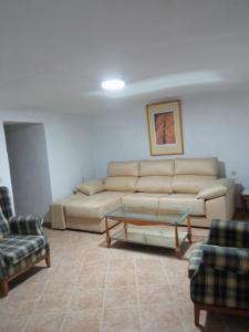 a living room with a couch and a table and chairs at Casa cueva rural Vico ideal grandes grupos in Freila