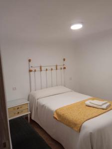 1 dormitorio con 2 camas y mesa con mesita de noche en Casa cueva rural Vico ideal grandes grupos, en Freila