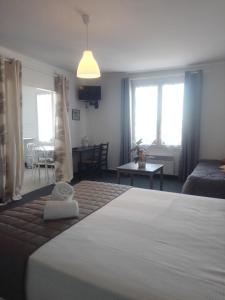 ein Schlafzimmer mit einem Bett und ein Wohnzimmer in der Unterkunft Hotel la coursive in La Cotinière