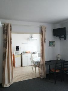 a kitchen and dining room with a table and a table and chairs at Hotel la coursive in La Cotinière