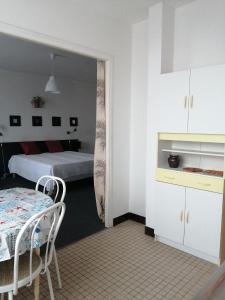 - une chambre avec un lit, une table et des chaises dans l'établissement Hotel la coursive, à La Cotinière