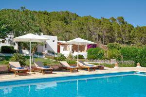 - une piscine avec des chaises et des parasols à côté d'une maison dans l'établissement Villa Mago, à Santa Gertrudis de Fruitera