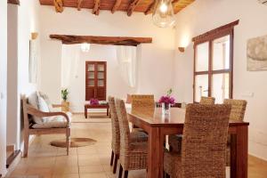 una sala da pranzo con tavolo e sedie in legno di Villa Mago a Santa Gertrudis de Fruitera
