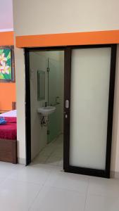 a bathroom with a sliding glass door with a sink at Taxa Uma Guest House in Kuta