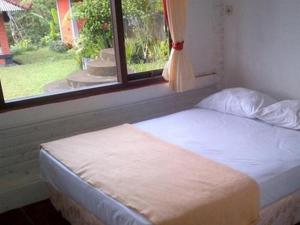 a bed in a room with a window at Villa Sinta in Baturiti