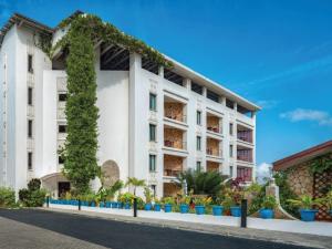 a white building with ivy on it at Coral Beach Hotel Dar Es Salaam in Dar es Salaam