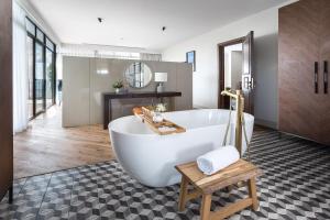 ein großes Bad mit einer Badewanne und einem Tisch in der Unterkunft Mizpe Hayamim by Isrotel Exclusive in Rosch Pina