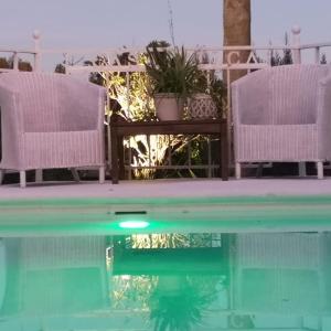 a pool with two chairs and a table and some water at Casa Silca in Marbella