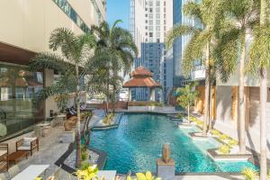 an infinity pool in a building with palm trees at Jasmine City Hotel in Bangkok