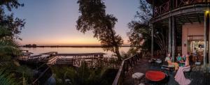 a group of people sitting on a deck near a lake at Chobe Marina Lodge in Kasane