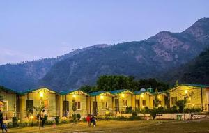 a row of houses with mountains in the background at Camp Brook - Luxury Camping in Rishikesh in Rishīkesh