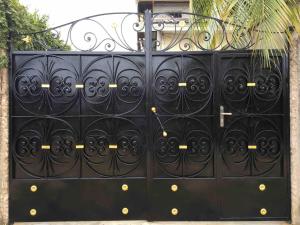 a black metal gate with gold studs on it at Appartement meublé haut standing Bonamoussadi (Kotto) in Douala