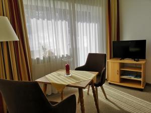 a room with a table and two chairs and a television at Schloss Fürstenstein in Berchtesgaden