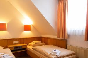 two beds in a room with a sloped ceiling at Hotel Kelkheimer Hof in Kelkheim