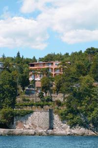 a building on top of a hill next to the water at VILLA VOLOSKO with private parking and breakfast,seaview in Volosko