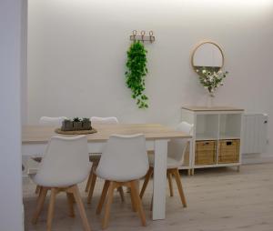 a dining room table with white chairs and a mirror at Piso recién reformado Galiano in Ferrol
