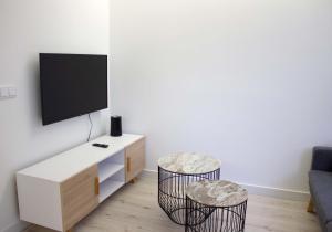 a living room with a tv and two stools at Piso recién reformado Galiano in Ferrol