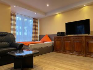 ein Wohnzimmer mit einem Sofa und einem Flachbild-TV in der Unterkunft Lotus in Plettenberg