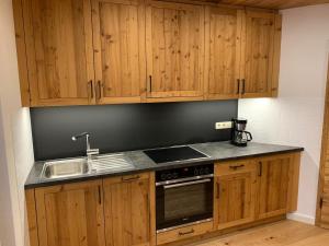 uma cozinha com armários de madeira e um lavatório em Ferienwohnung Moritz em Reit im Winkl
