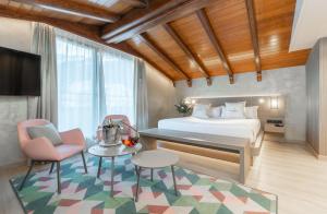 Schlafzimmer mit einem Bett, einem Tisch und Stühlen in der Unterkunft Grand Plaza Hotel & Wellness in Andorra la Vella