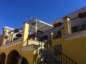 un edificio amarillo con una escalera delante en Pauli'S Holiday House, en Monserrato