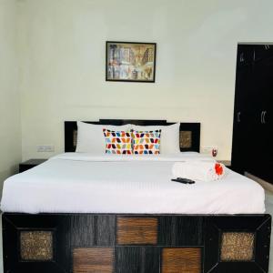 a bedroom with a large bed with white sheets at BluO Studio - Defence Colony - BathTub, Balcony in New Delhi