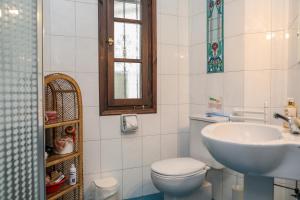 a bathroom with a white toilet and a sink at Golden View Villa in Skiathos Town +21 photos
