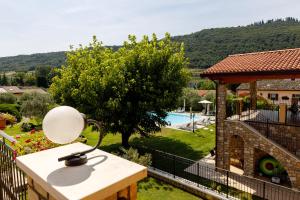 a lamp on a table next to a pool at Residence Rustico in Garda