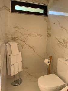 a bathroom with a white toilet and towels at Hotel Douro Vale de Campos in Penafiel