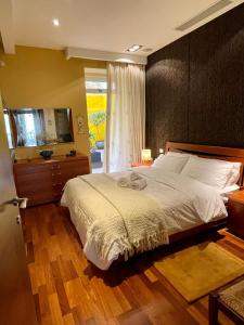 a bedroom with a large bed and a television at Valletta Collection - Merchant Str Apartment with large yard in Valletta