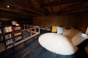a living room with a couch and a large rug at 囲炉裏つき古民家を丸ごと貸し切り「月夜見山荘」（庭にBBQグリル完成！） in Hayakawa