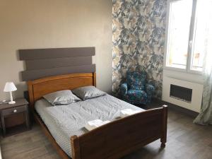 a bedroom with a bed and a chair and a window at Gites de l'aven in Orgnac-lʼAven
