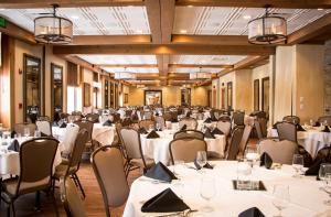 una sala banchetti con tavoli e sedie bianchi di Ironworks Hotel a Beloit