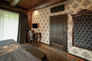a bedroom with a bed and a desk and a door at Timberjacks Siegen Motel in Siegen